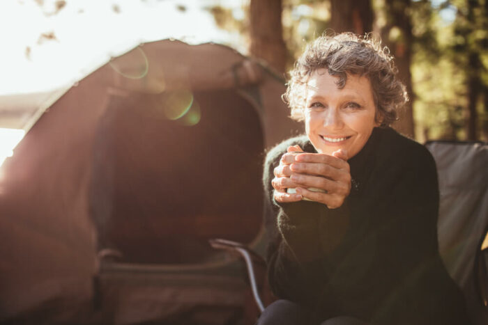 Mature woman, camping, holding a cup of tea