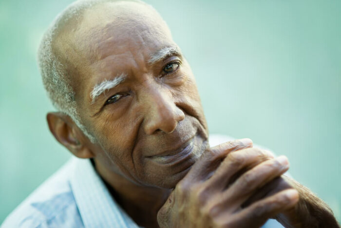 Older man looking at camera with small smile