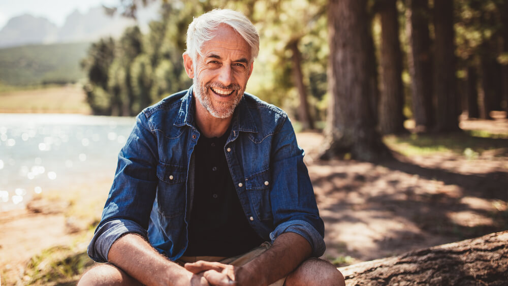 rustic senior man outdoors by lake